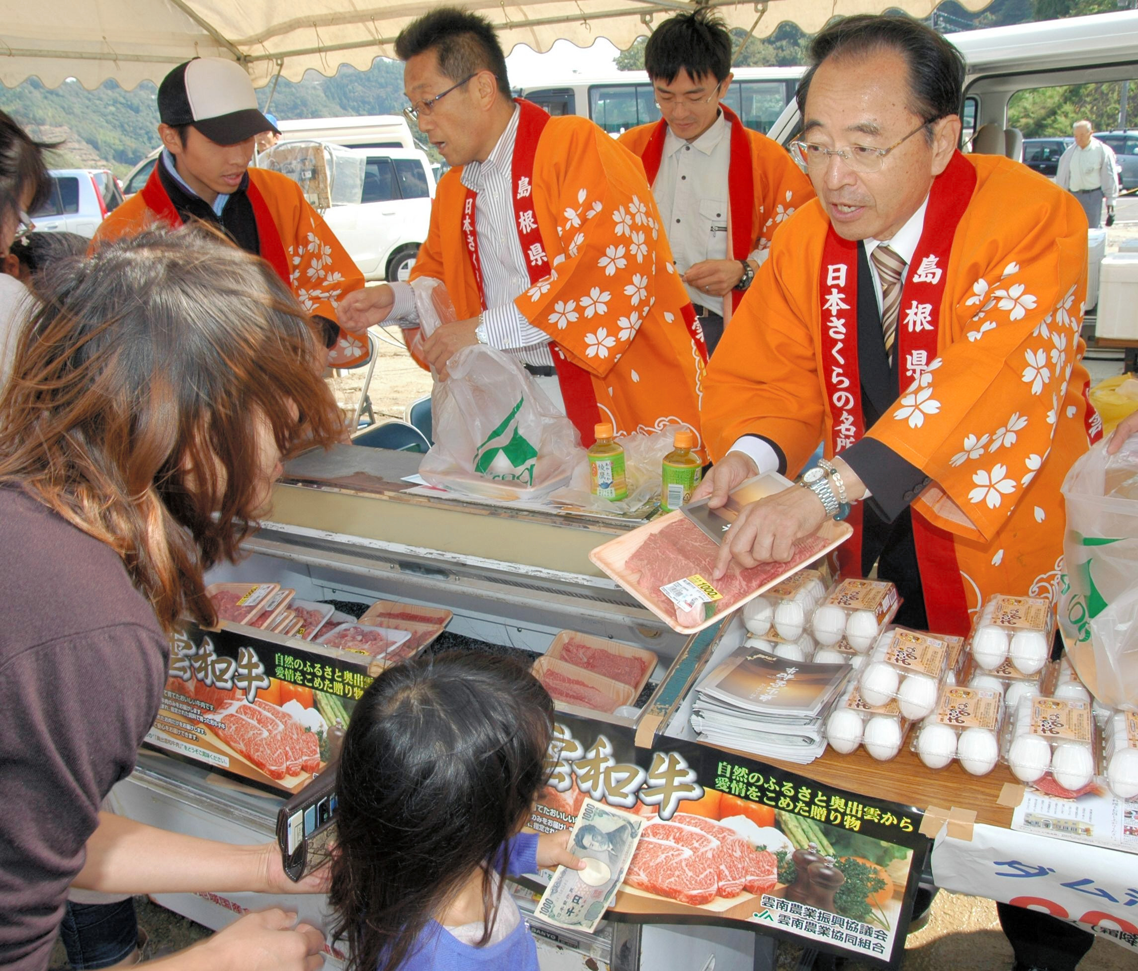 尾原ダム・さくらおろち湖祭りで、特産物を販売する速水雄一雲南市長（右）ら